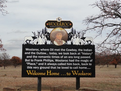 Sign for Woolaroc Museum, highlighting its historical significance and connection to the cowboy, Indian, and outlaw culture.