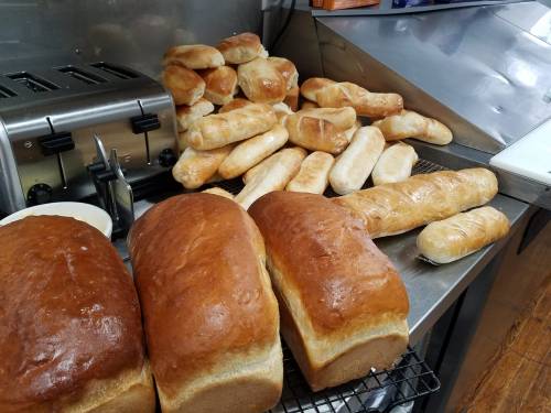 Freshly baked loaves of bread and rolls arranged on a countertop next to a toaster.