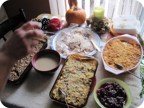 A festive table spread with turkey, stuffing, cranberry sauce, and pumpkin, ready for a holiday meal.