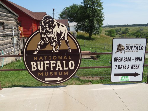 Sign for the National Buffalo Museum, featuring a buffalo graphic, with hours and ATM information.