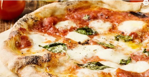 Close-up of a freshly baked pizza topped with tomato sauce, mozzarella cheese, and fresh basil leaves.