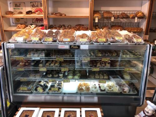 A display case filled with a variety of baked goods, including cookies, pastries, and cupcakes.
