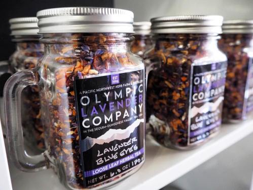 Glass jars filled with loose leaf lavender, labeled "Olympic Lavender Company" with a scenic mountain design.
