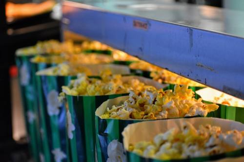 Close-up of brightly colored popcorn bags filled with freshly popped popcorn, illuminated from below.