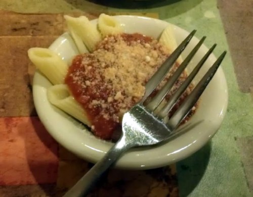 A small bowl of pasta with marinara sauce and grated cheese, accompanied by a fork resting beside it.