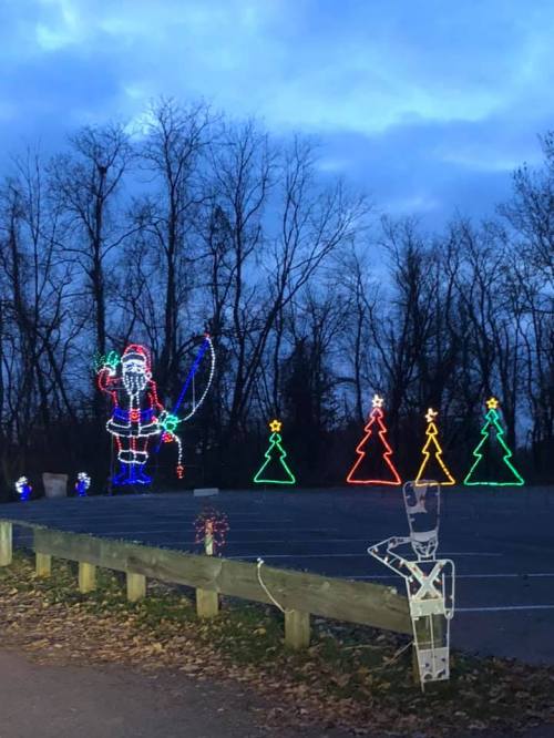 Colorful holiday lights display featuring Santa, Christmas trees, and a nutcracker in a park setting.
