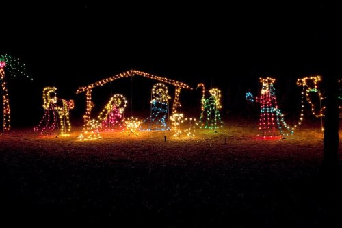 Colorful Christmas lights depicting a nativity scene in a dark setting.