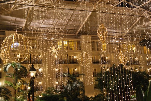 A beautifully decorated indoor space with hanging lights and large illuminated ornaments, creating a festive atmosphere.