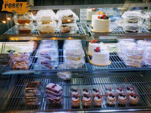 Display case filled with various desserts, including cakes, cupcakes, and pastries, all beautifully arranged.