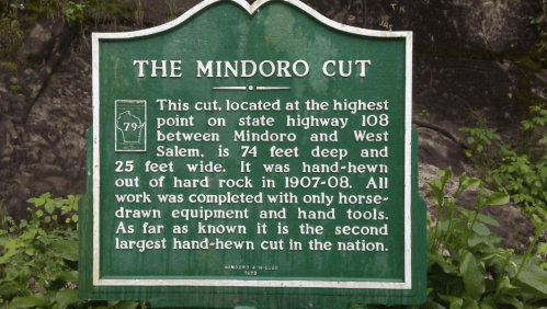 Sign detailing the Mindoro Cut, a historic rock cut on highway 108, 74 feet deep and 25 feet wide, completed in 1907.