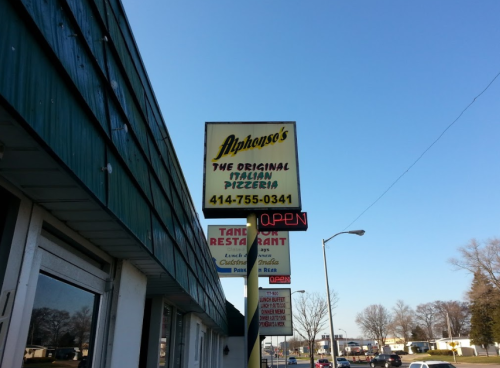 Sign for Alphonso's, an Italian pizzeria, with contact number and "OPEN" displayed. Clear blue sky in the background.