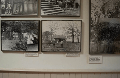 A gallery wall displaying historical black-and-white photographs in framed displays.