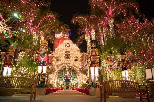 A festive display of lights and nutcracker statues in a beautifully decorated holiday scene at night.