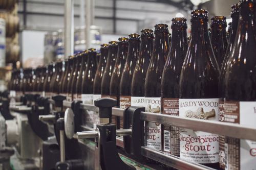 A row of bottles filled with gingerbread stout on a production line in a brewery.