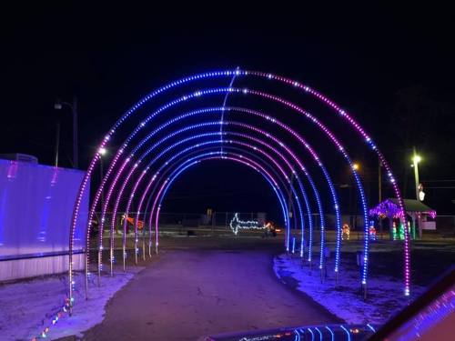 A colorful light tunnel with purple and blue lights, set against a dark night sky.
