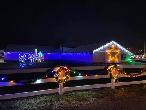 A festive building decorated with colorful lights and holiday decorations, including angels and a Christmas scene.