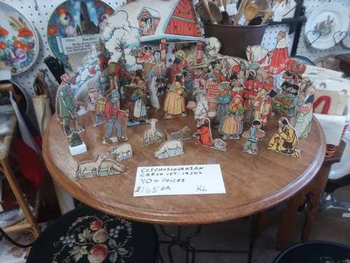 A colorful display of vintage paper figures and animals on a wooden table, with a price tag of $165.00.