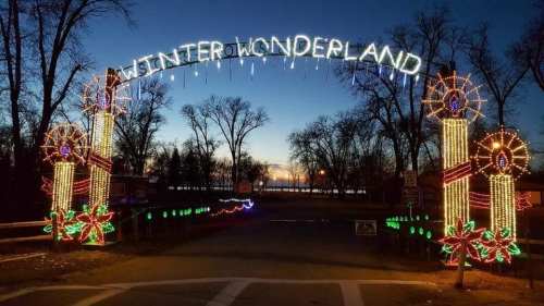 A festive archway reading "Winter Wonderland" adorned with lights and decorations, set against a twilight sky.