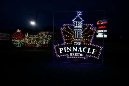Colorful holiday lights display featuring "The Pinnacle Bristol" and "Speedway Lights" signs at night.