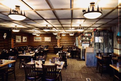 Cozy restaurant interior with wooden decor, tables set for dining, and rustic lighting fixtures.