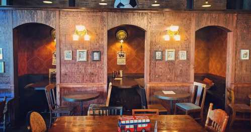 Cozy pub interior with wooden booths, tables, and vintage decor, featuring a soccer ball hanging from the ceiling.