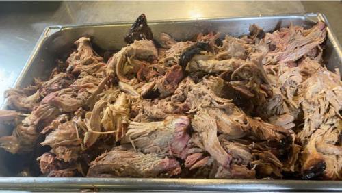 A large tray filled with shredded, cooked meat, showcasing a mix of textures and colors.