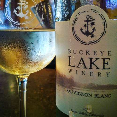 A glass of Sauvignon Blanc next to a bottle from Buckeye Lake Winery, featuring an anchor logo.