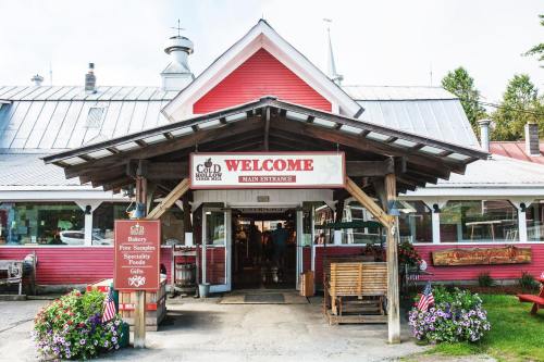 A charming red building with a welcoming sign, featuring a main entrance and decorative flowers.