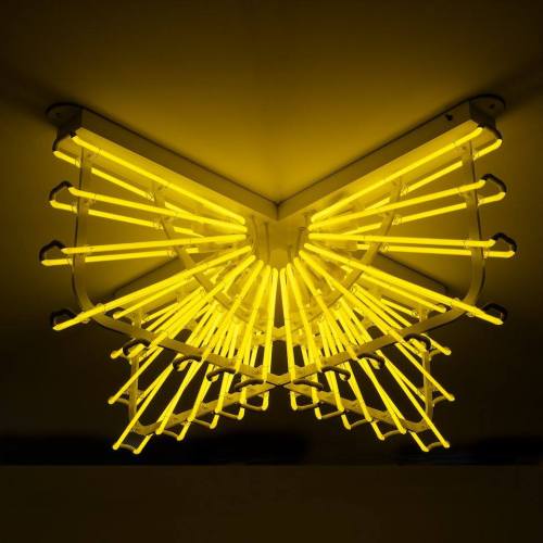 A unique ceiling light fixture with yellow neon tubes arranged in a sunburst pattern.