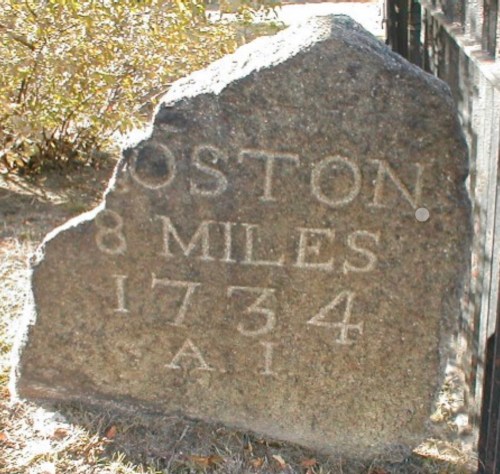 Milestone marking 8 miles to Boston, dated 1734, made of stone with engraved text.