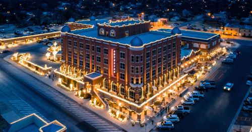 Aerial view of a beautifully lit hotel decorated with festive lights during the evening.