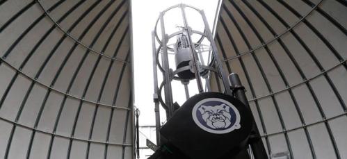 A large industrial structure with a cylindrical design, featuring a central tower and a bulldog logo at the base.