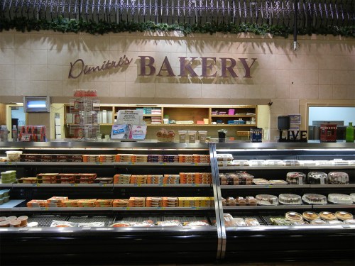 A bakery display featuring various baked goods and desserts, with a sign reading "Demetri's Bakery" above.