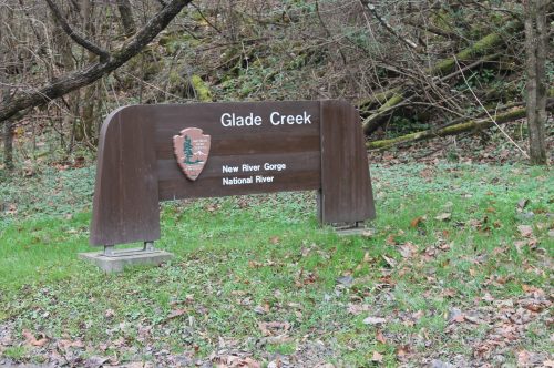 Sign for Glade Creek at New River Gorge National River, surrounded by trees and fallen leaves.