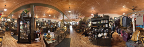 A panoramic view of a cozy antique shop filled with vintage items, clothing, and decorative pieces.