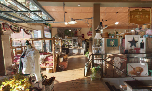 A cozy, rustic shop interior with wooden displays, vintage decor, and warm lighting, inviting customers inside.