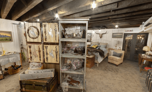 A rustic interior featuring wooden decor, a cozy bed, and various cowboy-themed items displayed on shelves.