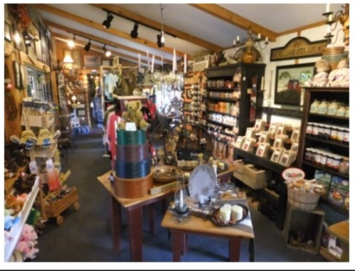 A cozy shop interior filled with various crafts, home goods, and decorative items on shelves and tables.