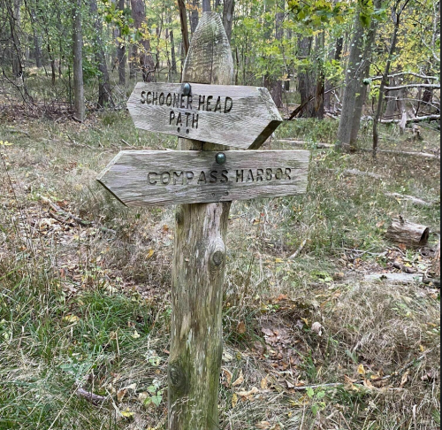 Wooden signpost in a forest, pointing to "Schooner Head Path" and "Compass Harbor."