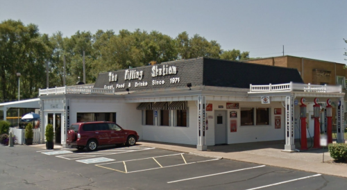 A retro-style diner named "The Filling Station," featuring a black roof and vintage gas pumps outside.