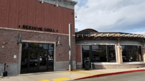 Exterior of Beehive Grill, featuring a brick facade, large windows, and a covered entrance.