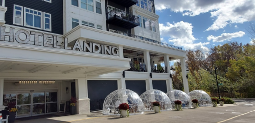 Exterior of Hotel Landing featuring clear dining domes and a modern architectural design under a blue sky.