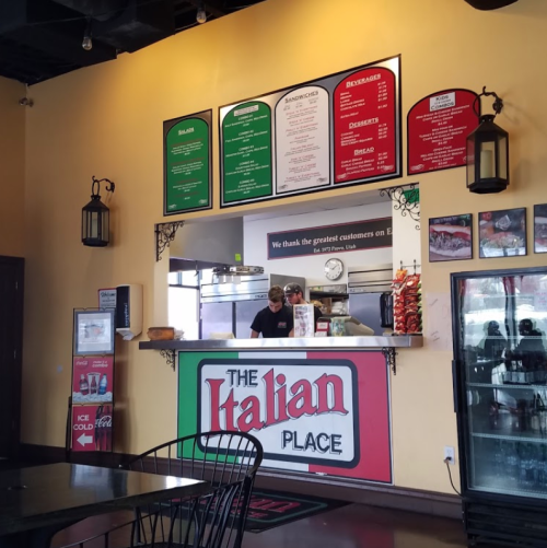 Interior of an Italian restaurant with a menu board, staff at the counter, and a welcoming atmosphere.