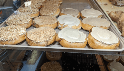 A tray of donuts topped with nut and cream frosting, showcasing a variety of textures and flavors.