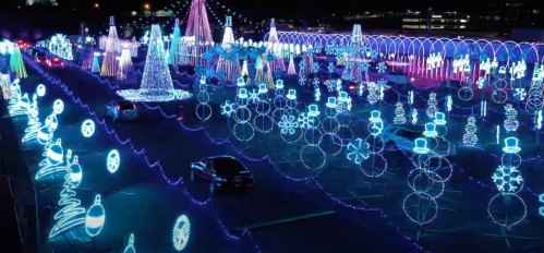 A vibrant display of colorful holiday lights featuring trees, snowmen, and festive decorations in a nighttime setting.