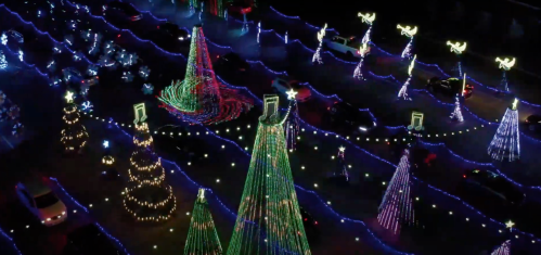 Aerial view of colorful Christmas light displays featuring decorated trees and musical notes in a festive setting.