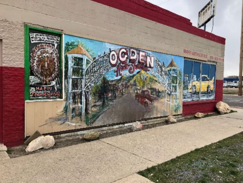 Mural on a building featuring "Ogden" with a vintage car and Thanksgiving-themed artwork.