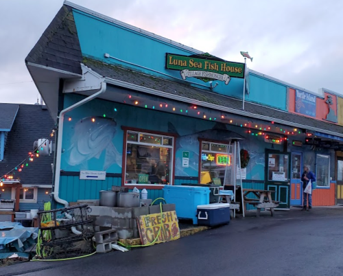 Colorful exterior of Luna Sea Fish House with festive lights, open sign, and fresh crab display outside.