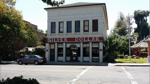 Historic building with "Silver Dollar" sign, featuring large windows and a classic architectural style.