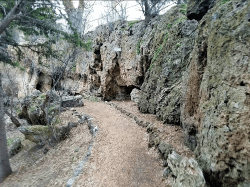 A winding path through a rocky landscape, surrounded by trees and natural formations.
